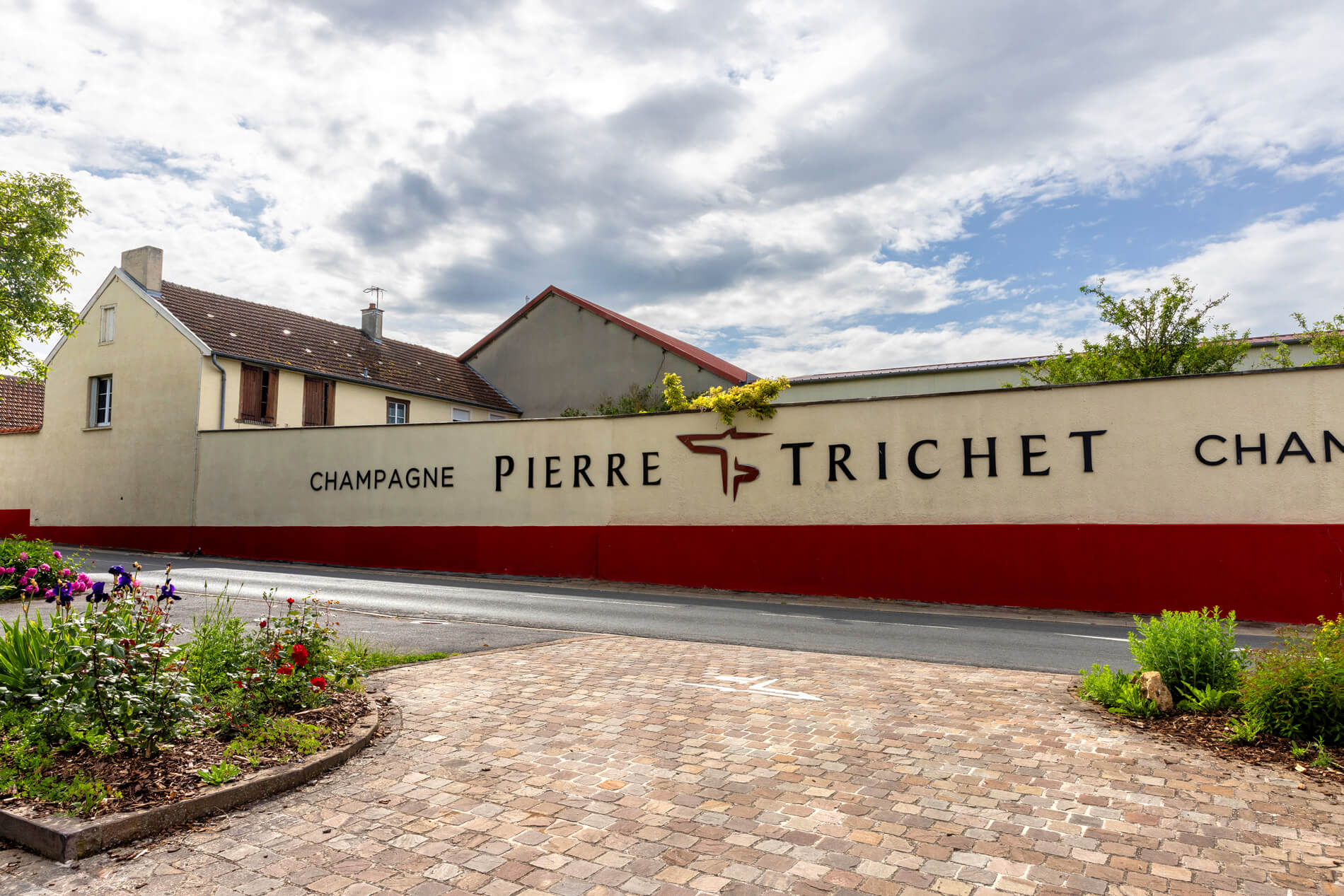 La maison Pierre Trichet vue de l'extérieur avec le logo champagne Pierre Trichet écrit en grand sur le mur