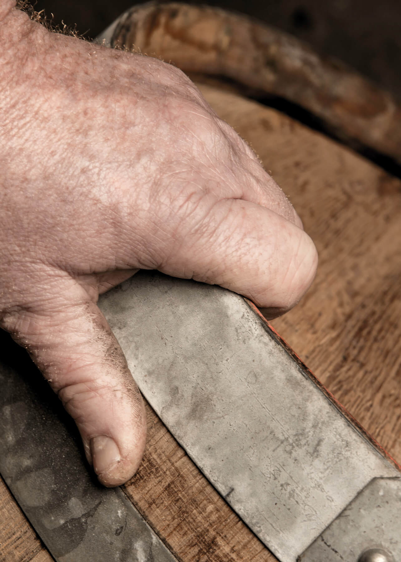 Close-up of Pierre Trichet's hand holding an oak barrel in which he ages certain vintages